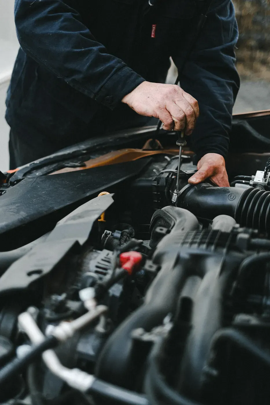 Mechanik provádí servis motoru automobilu