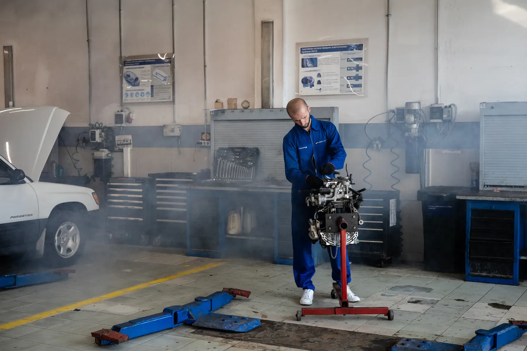 Mechanik opravuje motor v autoservisu